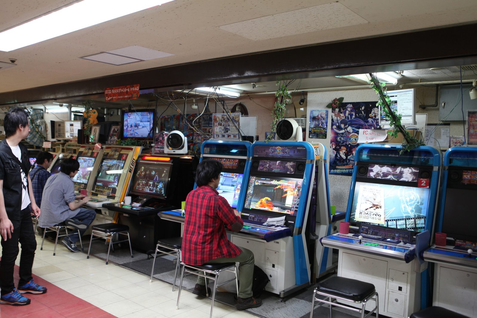 Interior of a Japanese arcade venue with rows of arcade machines and gaming stations