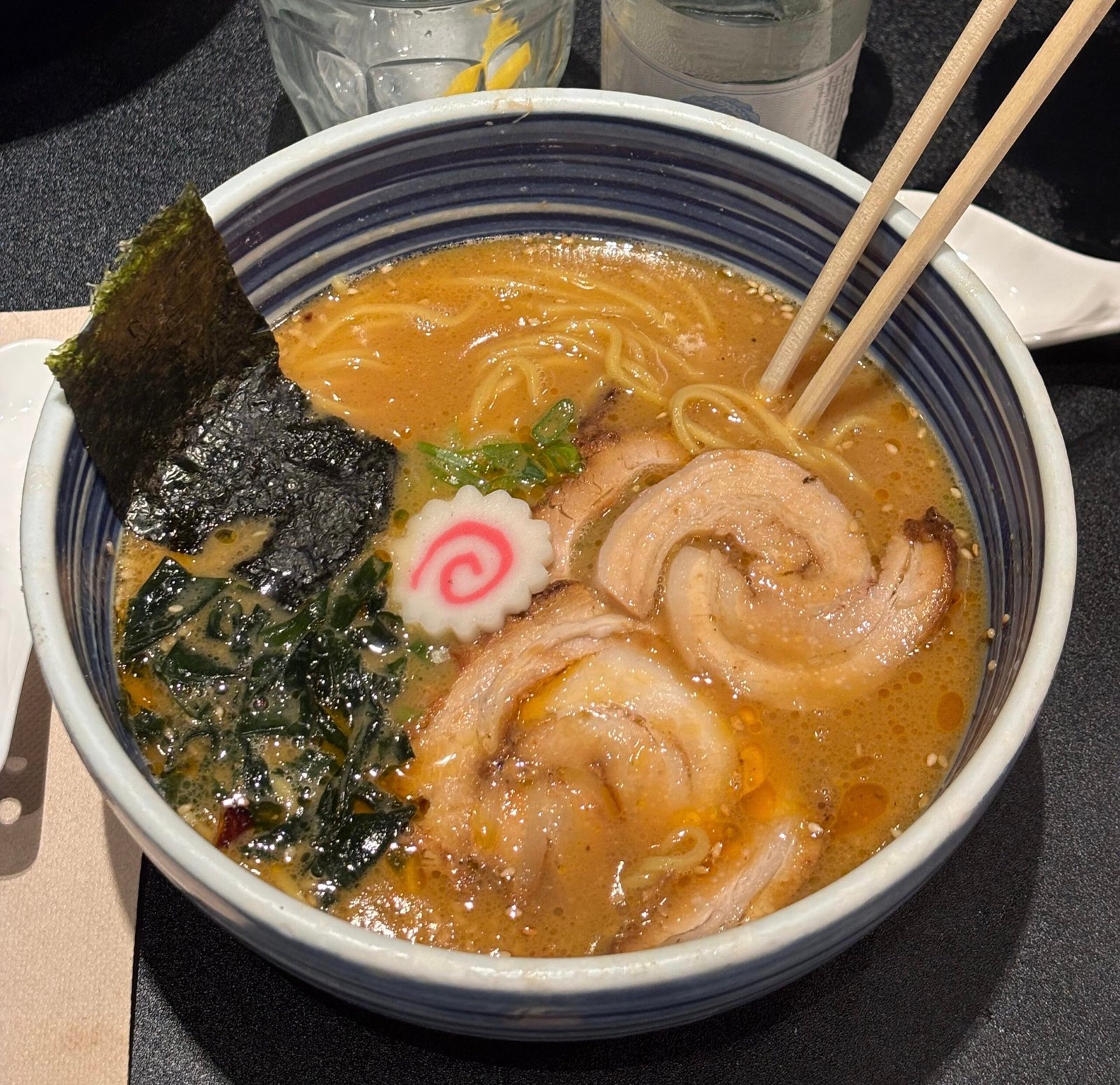 A bowl of miso ramen showing chashu pork, nori, narutomaki fish cake and soft-boiled egg