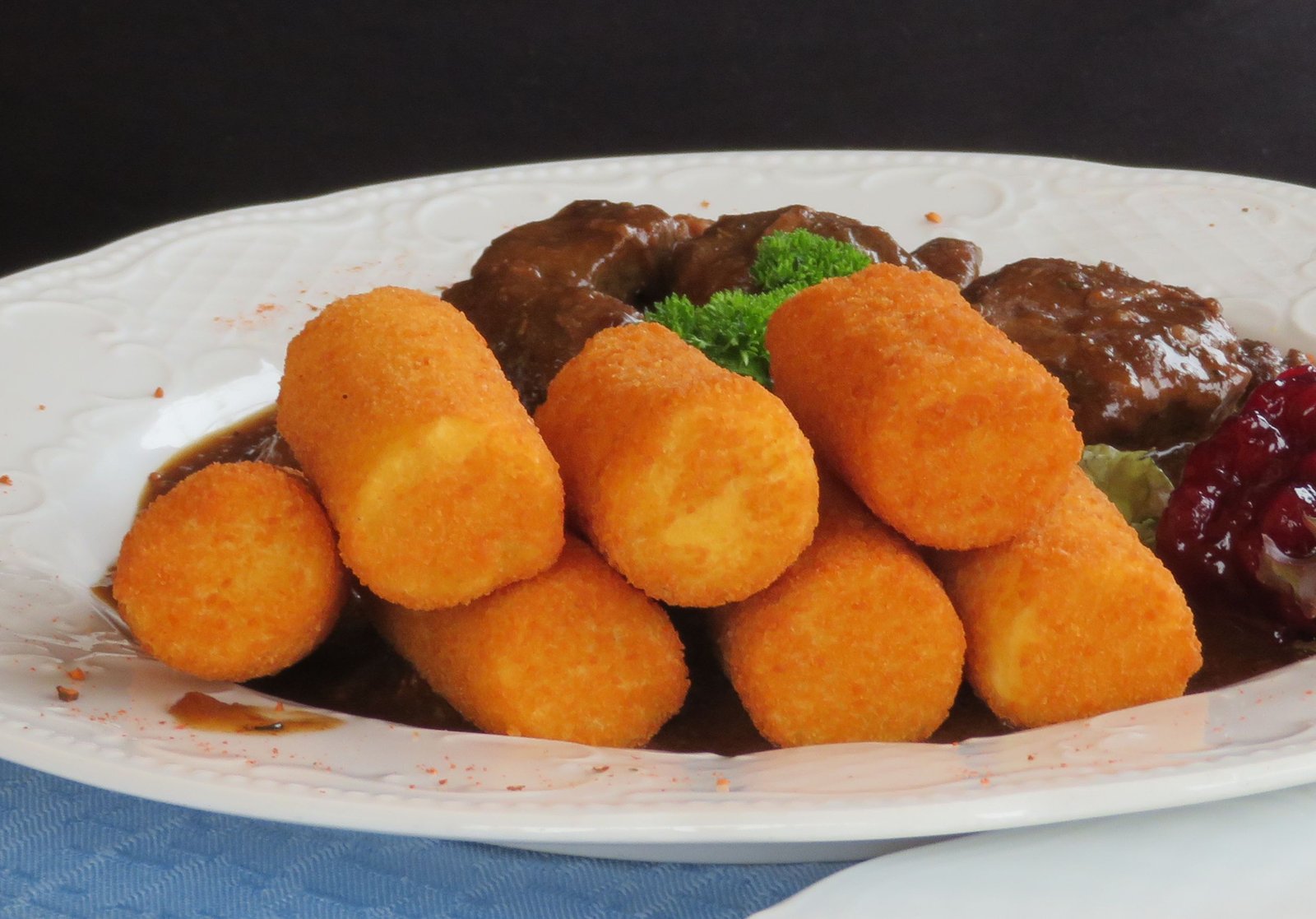 Fried potato croquettes served with beef stew