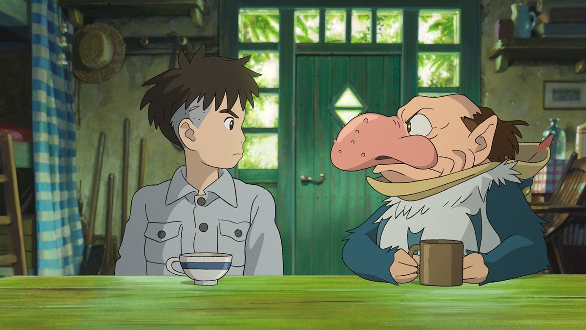 Mahito sitting at a table across from the Grey Heron in The Boy and the Heron