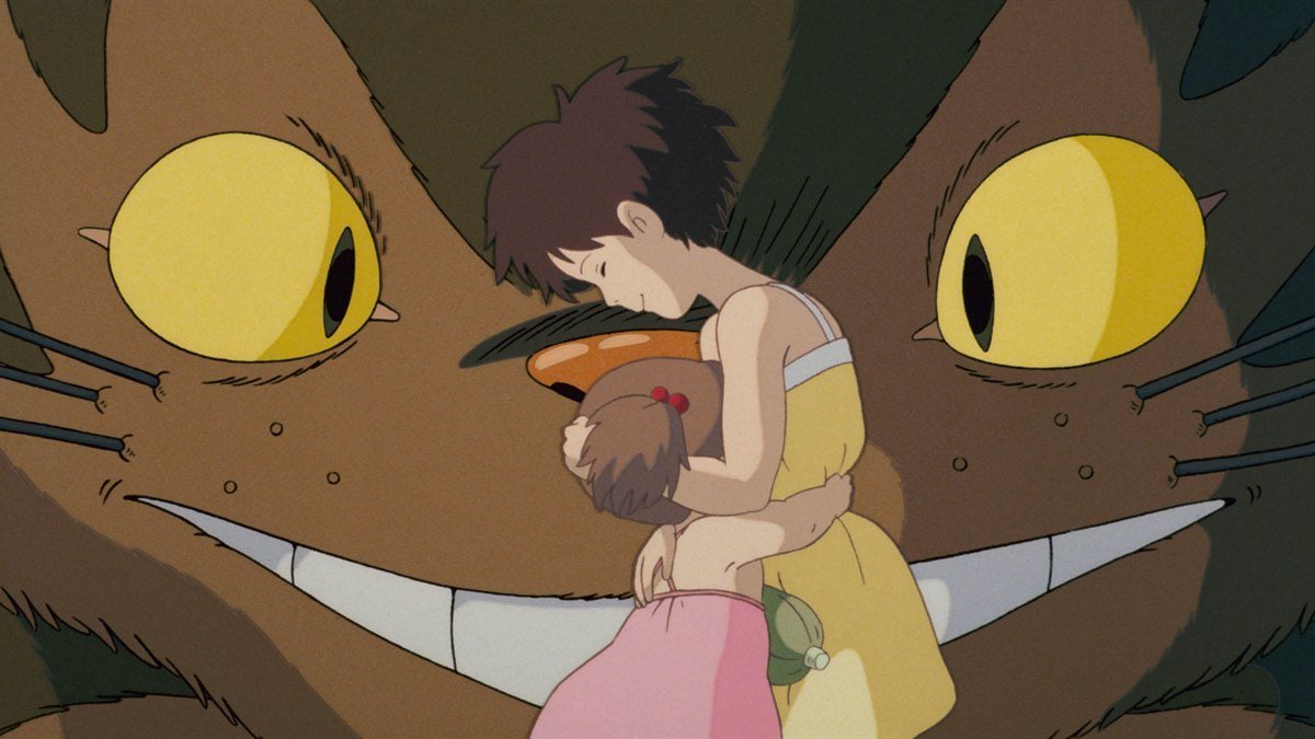 Satsuki hugging Mei in front of the grinning Catbus in My Neighbor Totoro