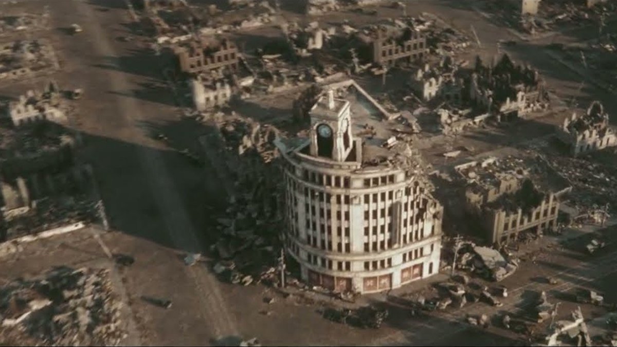 An aerial view of a ruined city with a clock-tower building in Godzilla Minus Zero