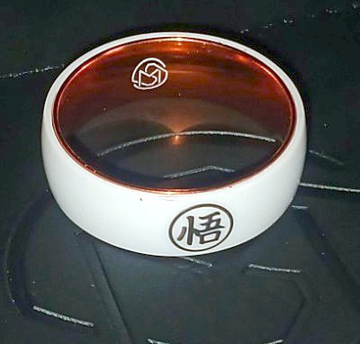 Close-up of the Go kanji on the white outer band of the MugenSense Son Goku ring, with the logo inside